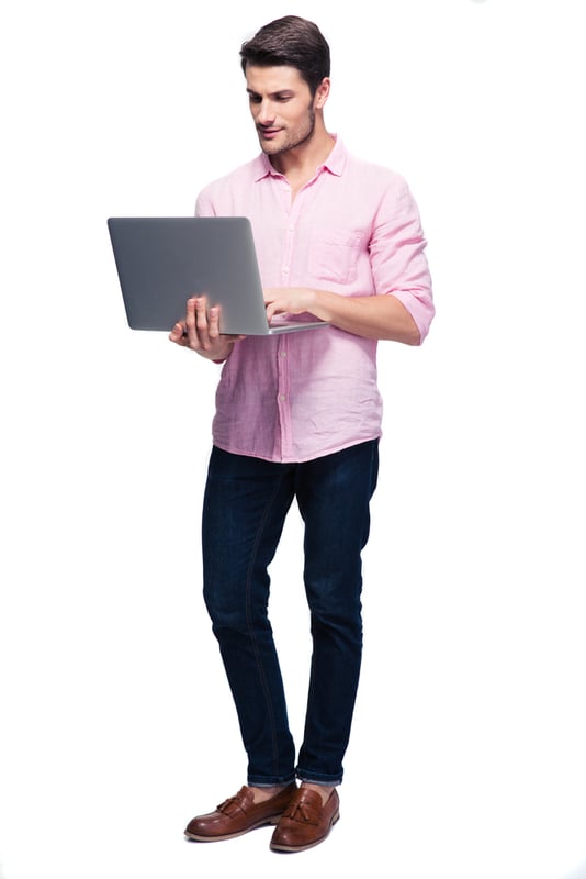 Young man standing and using laptop isolated on a white background